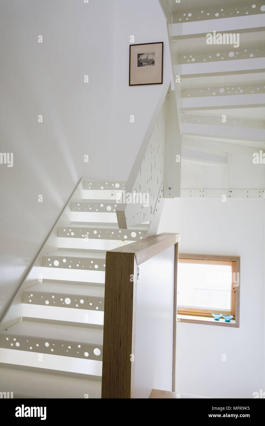 Contemporary staircase with light shinning through holes cut in the treads Stock Photo