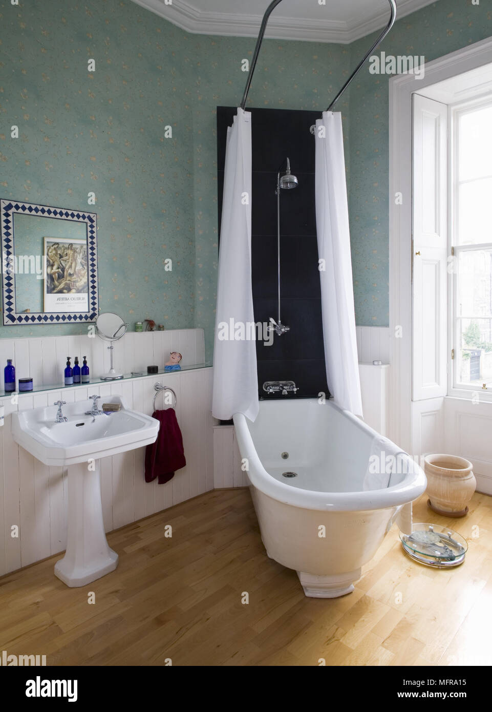 Old fashioned style freestanding roll top bathtub with overhead shower  Stock Photo - Alamy