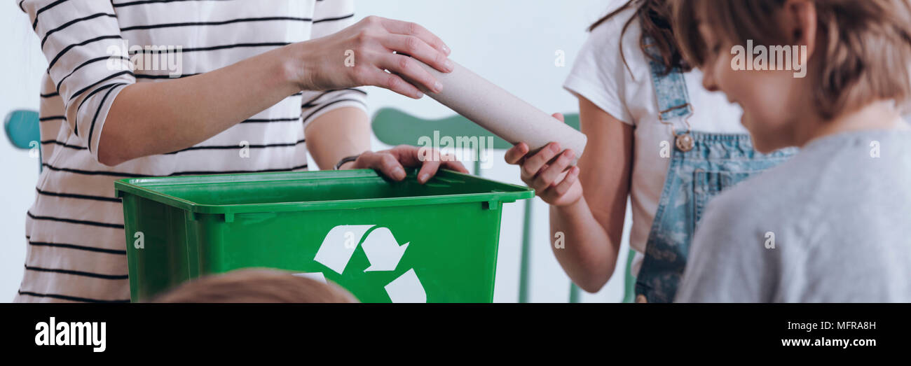 Close-up panorama of a school girl handing a paper tube to a teacher ...