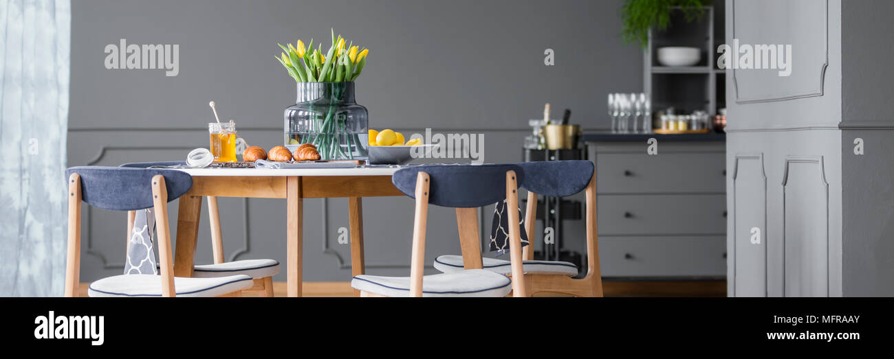 Yellow Tulips On Wooden Dining Table With Chairs In Grey Rustic Dining Room Interior Stock Photo Alamy