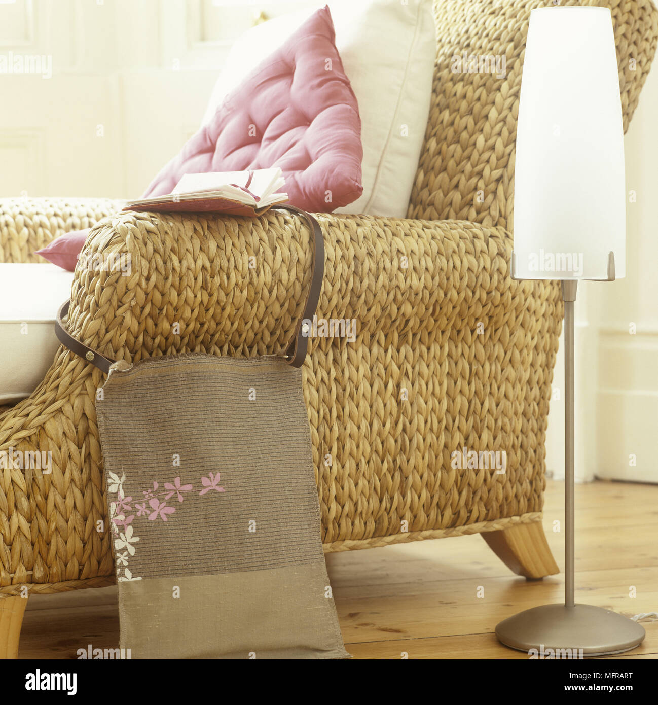 Country Style Wicker Chair With Cushions Next To Floor Lamp
