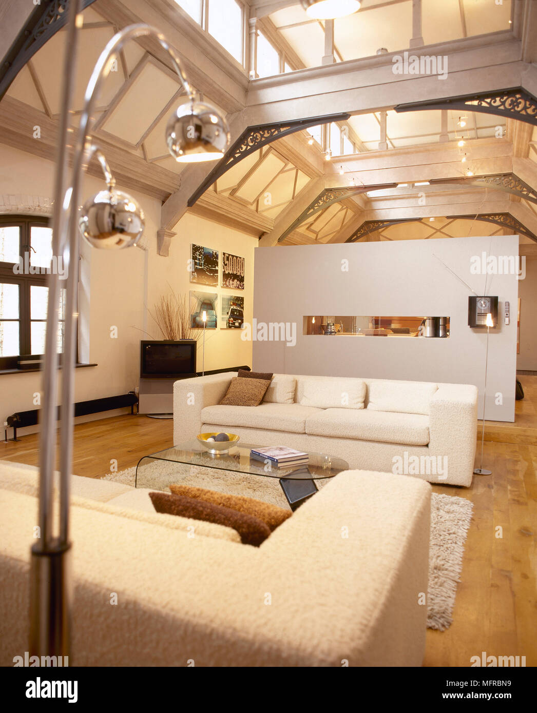 Open plan sitting room with sofas, glass coffee table, partition wall