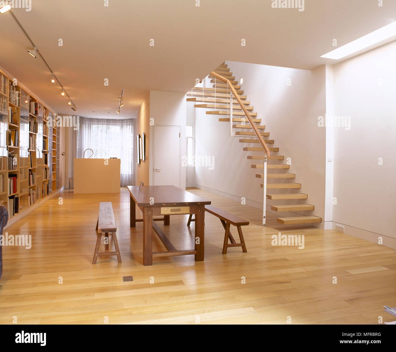 Open Plan Living Area With Dining Table And Benches Wood Floor