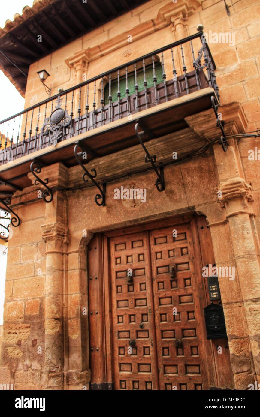 Old stone facade made of carved stone and vintage wooden door in a ...