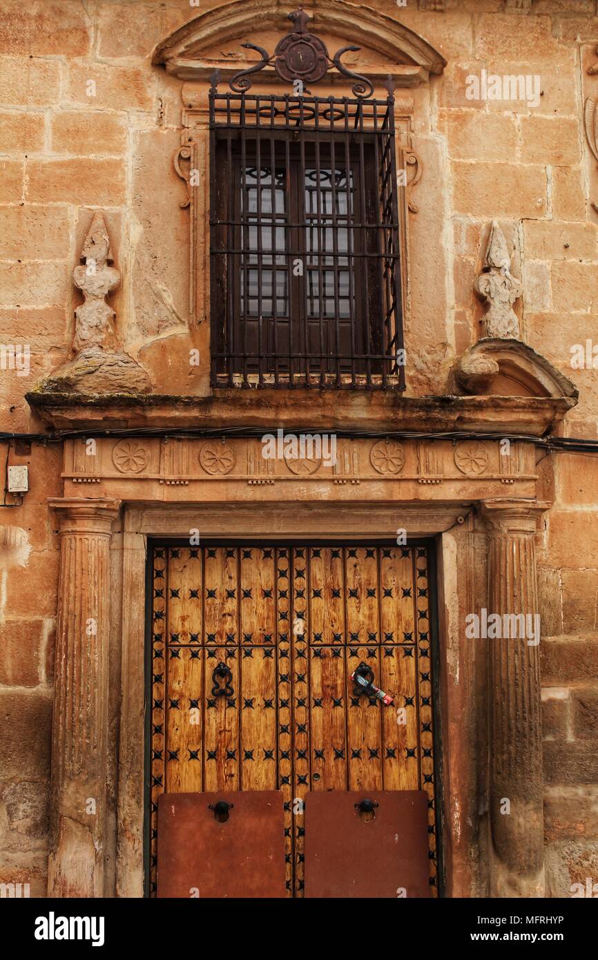 Old stone facade made of carved stone and vintage wooden door in a ...