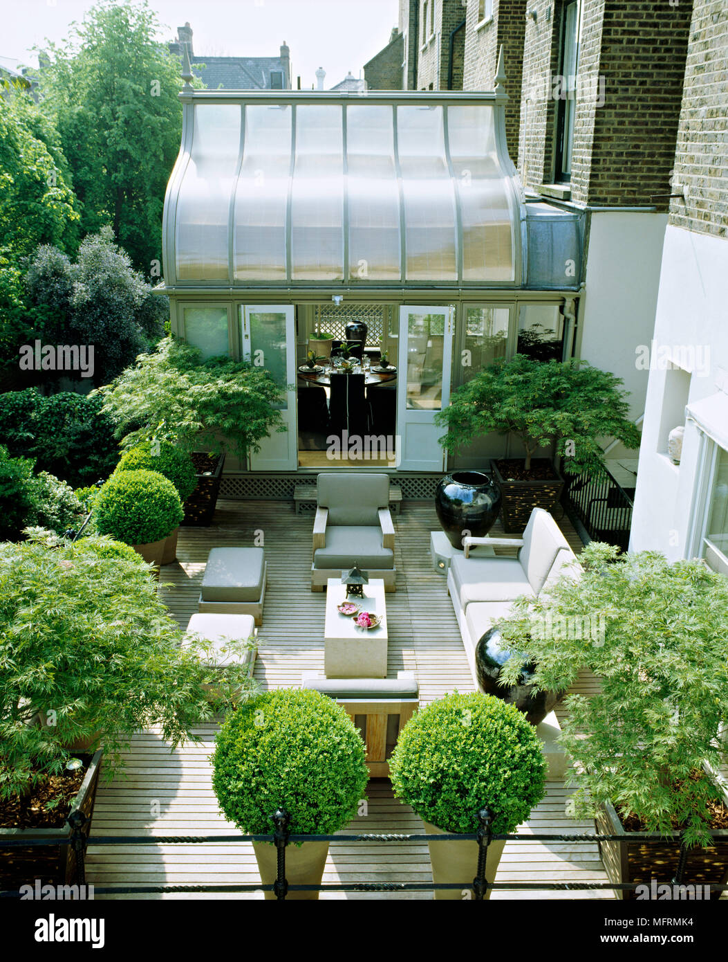 A modern town garden roof terrace with decked patio area table and