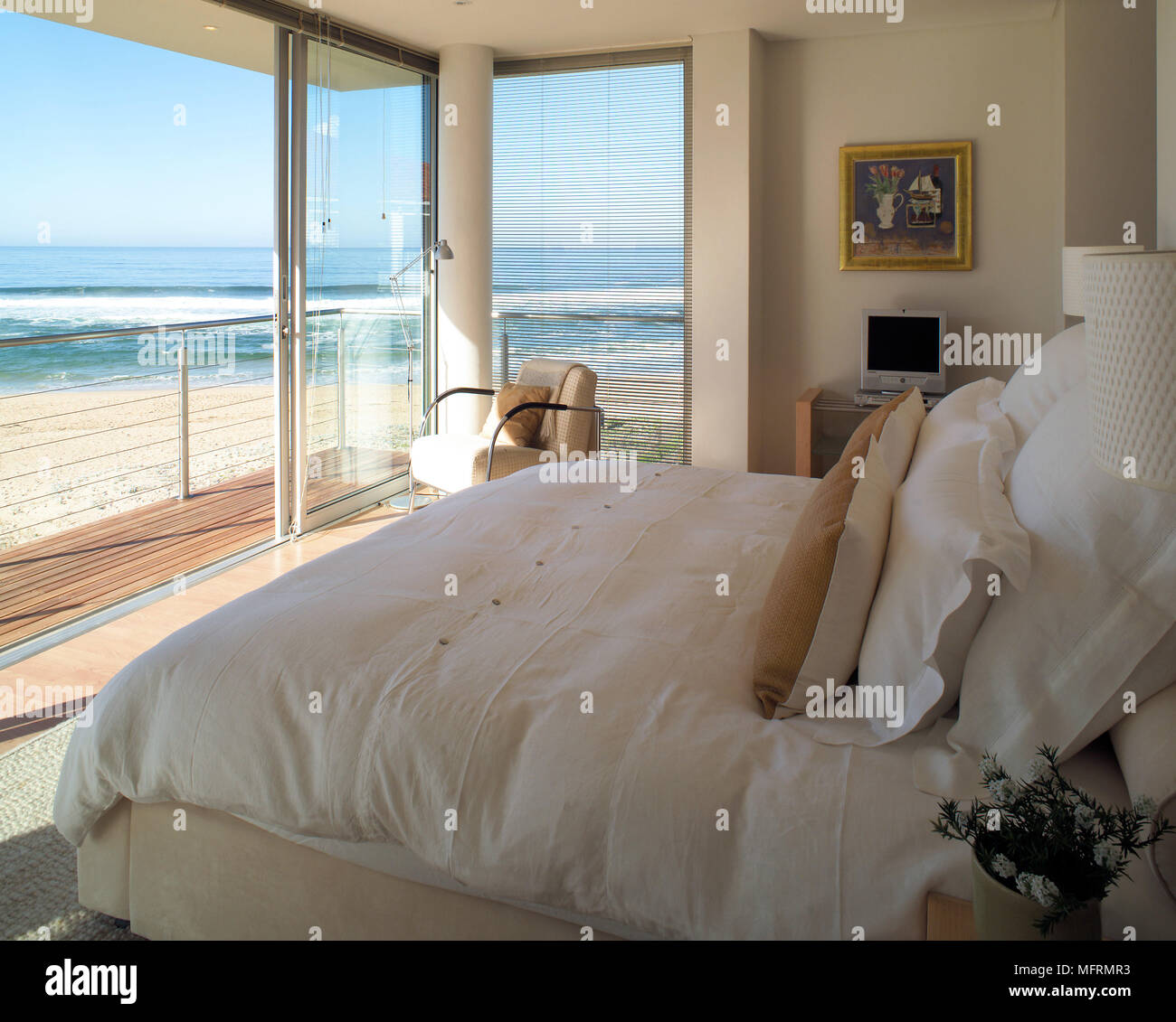 A modern neutral bedroom with double bed sliding glass doors opening
