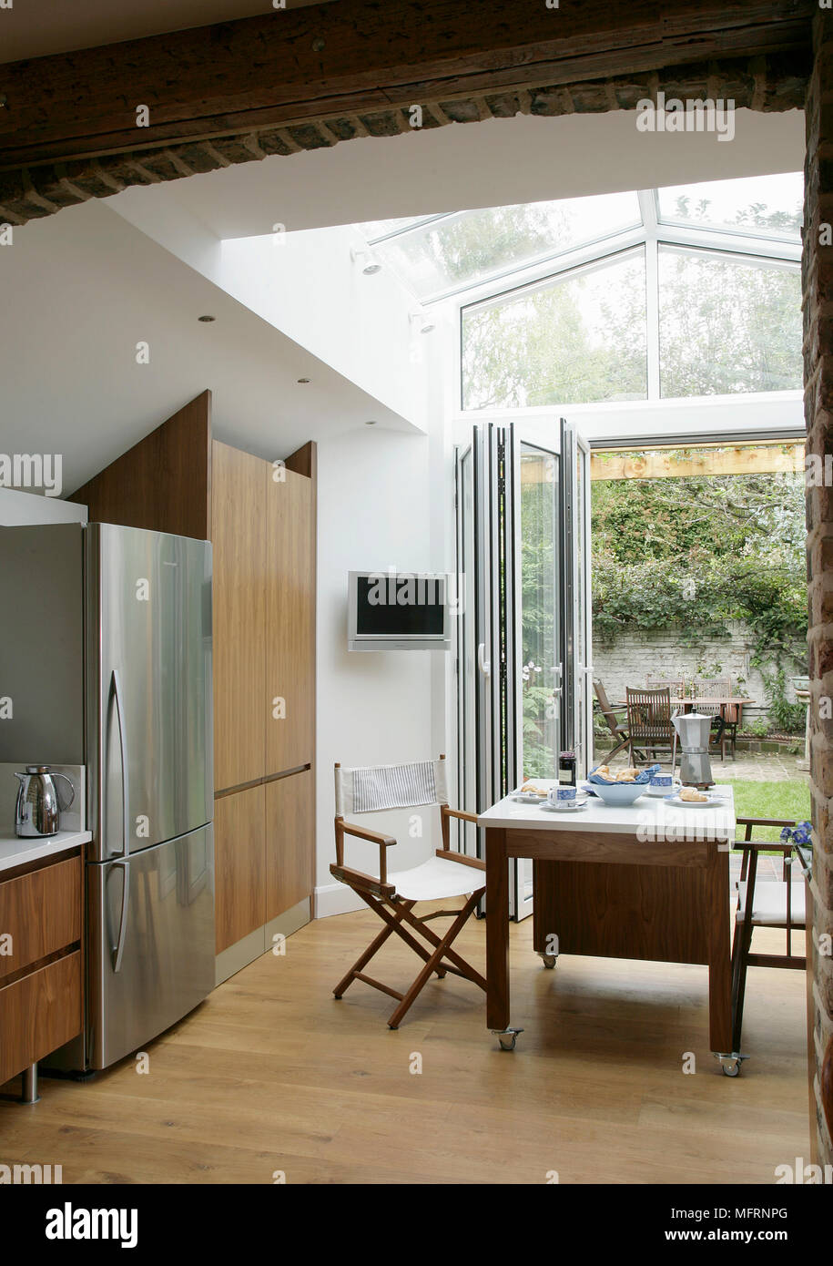 Table For Two In Modern Kitchen With Folding Patio Door Stock