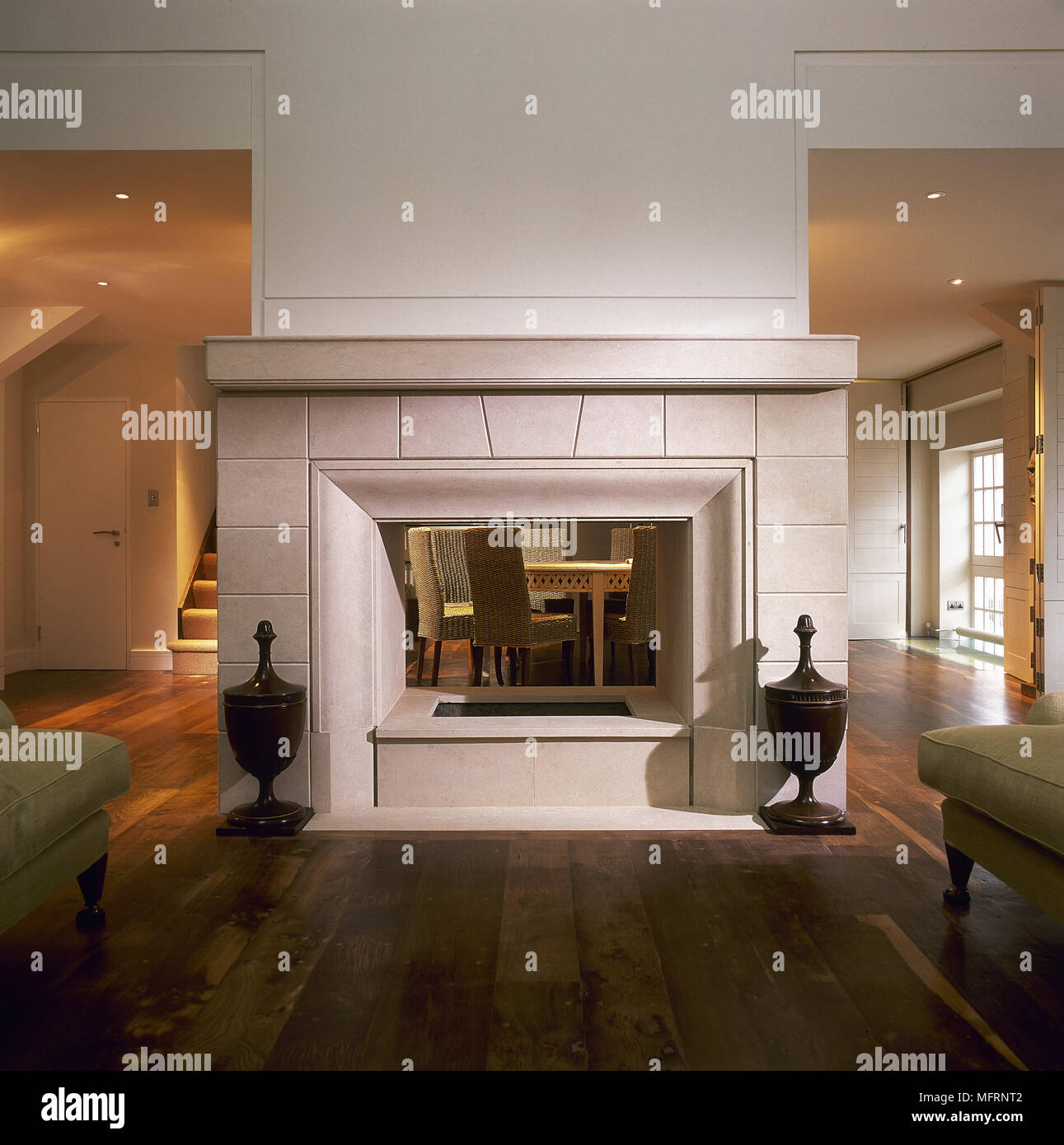 Stone Tiled Fireplace Set In Centre Of Room Stock Photo