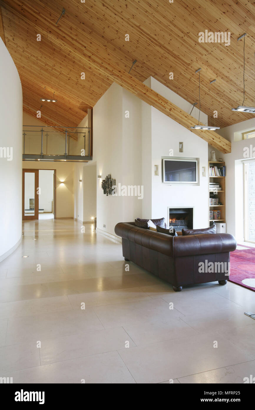 Leather sofa in front of fireplace with lit fire in spacious sitting