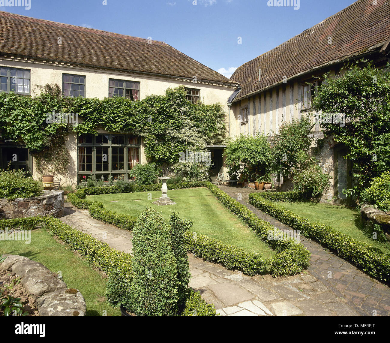 Exterior of Tudor country house and barn with landscaped garden, Stock Photo