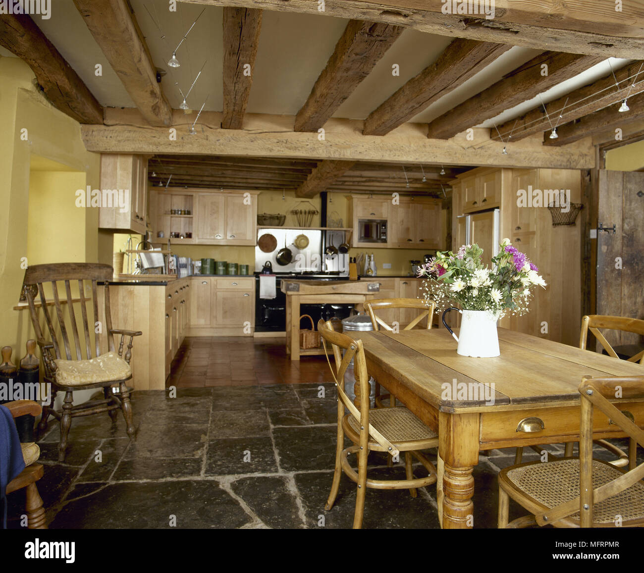 Country Yellow Kitchen And Dining Area With Beamed Ceiling