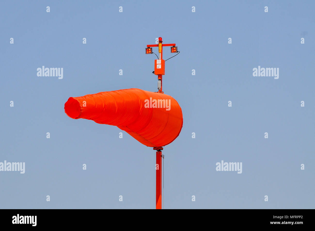 Orange Windsock on a blue sky background Photographed in an airfield in