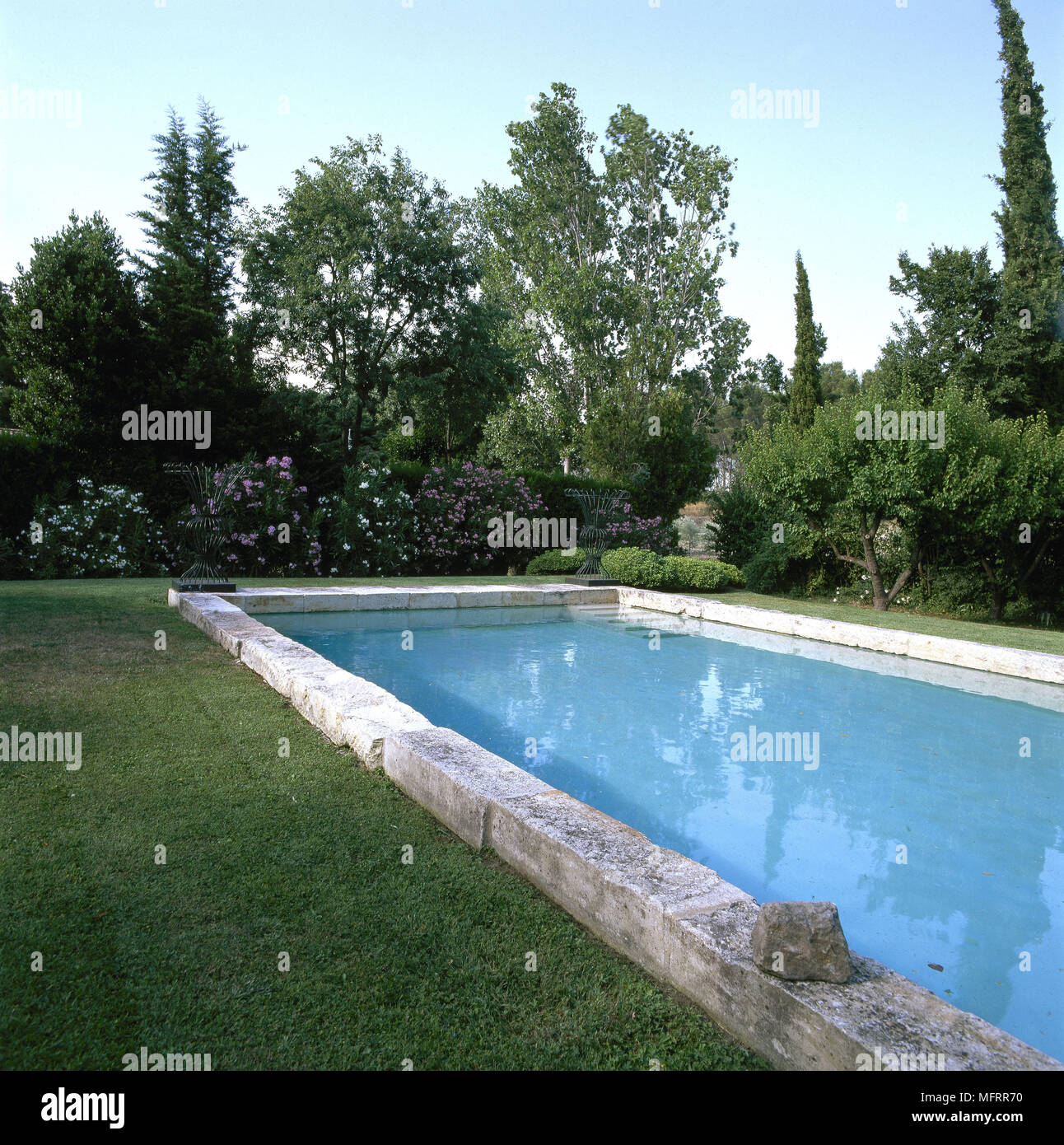 Garden and grass around outdoor swimming pool. Stock Photo