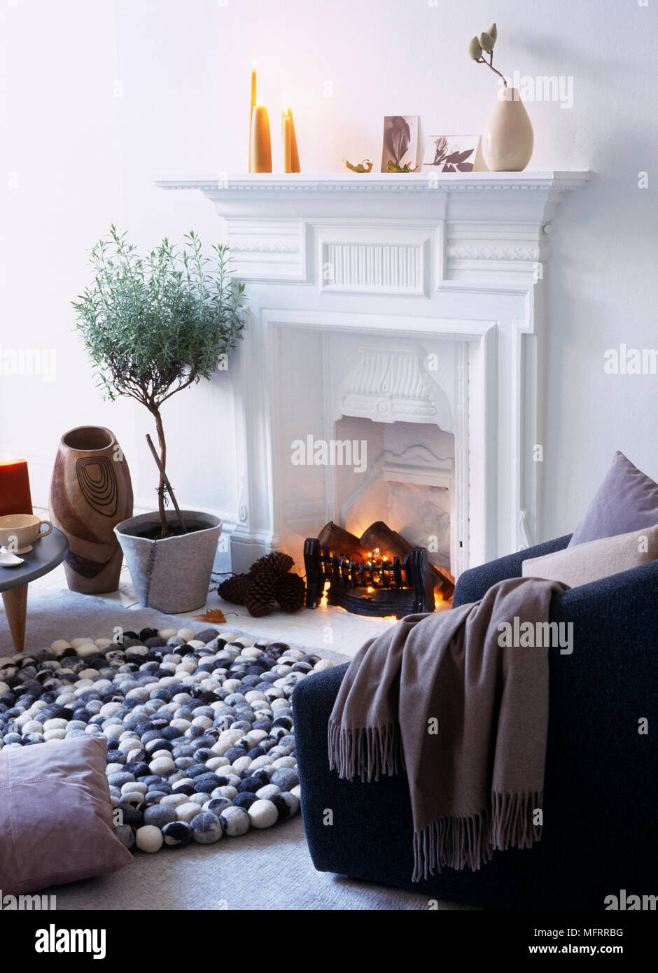 Lit Fire In Fireplace In Modern Sitting Room Stock Photo