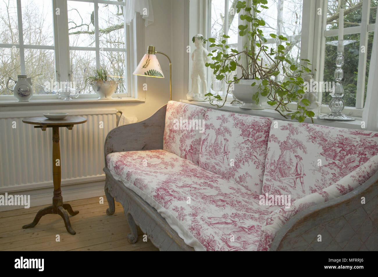 Swedish sitting room with white painted walls and toile de Juoy sofa. Stock Photo