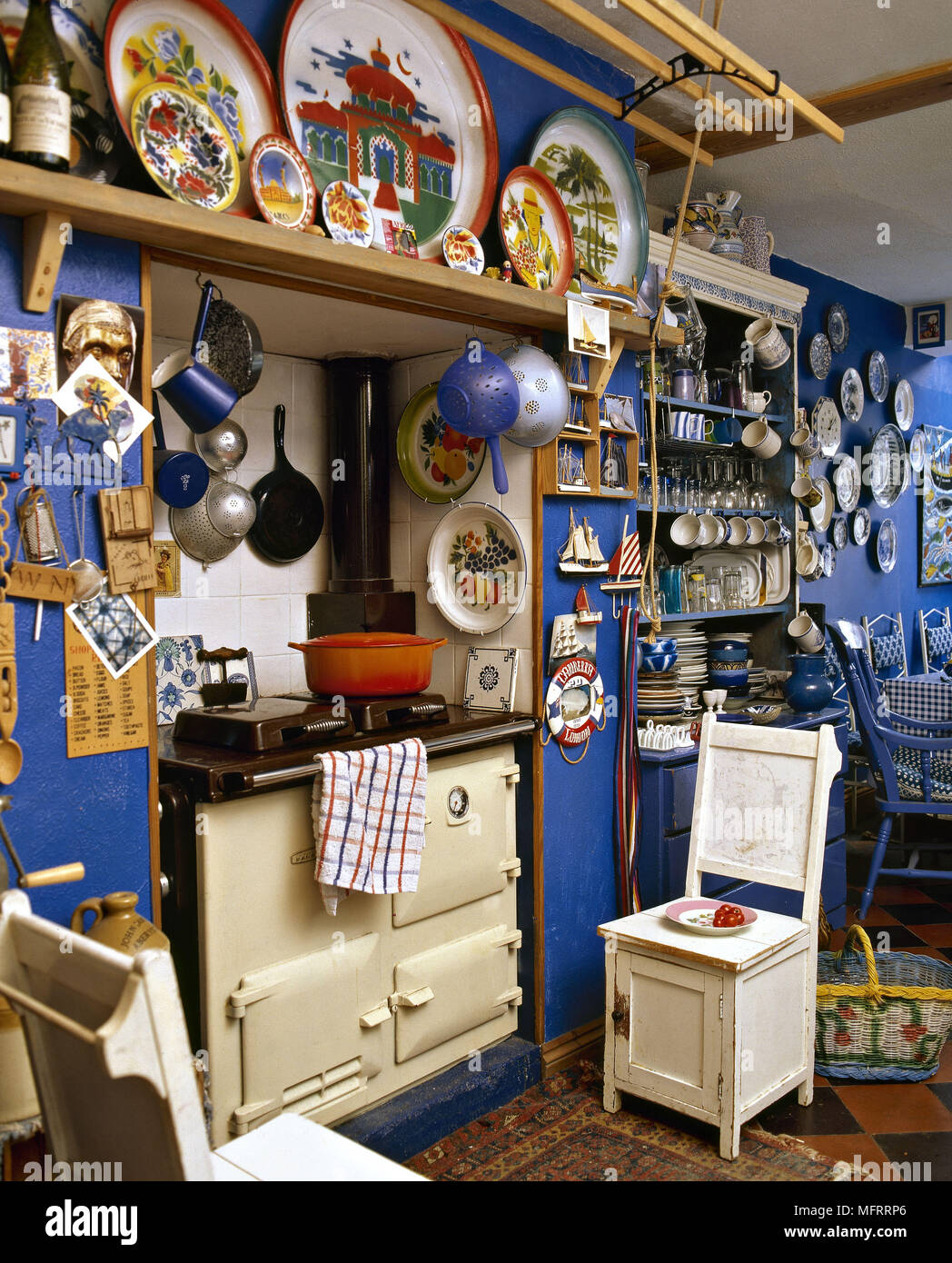 A traditional country style blue kitchen with cream Aga ceramic wall plates Stock Photo