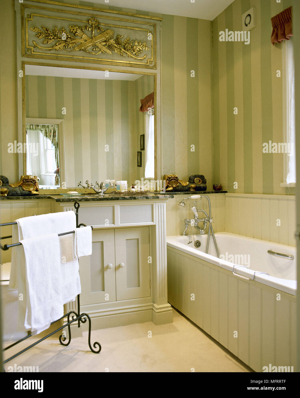 Bathroom with striped wallpaper and painted panelling. Stock Photo