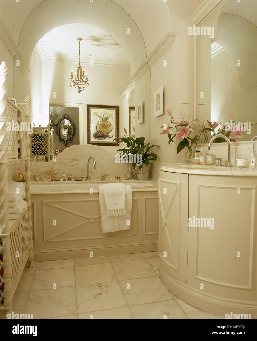 Cream panelled bathroom with marble bath surround and tiled floor Stock