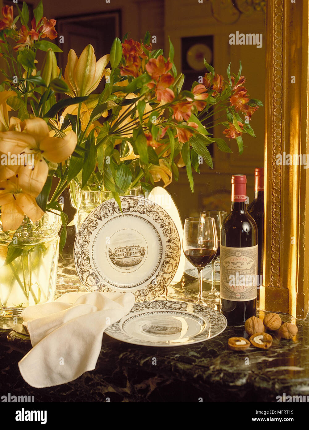 Decorative China Plates And Flower Arrangement Next To Bottle Of