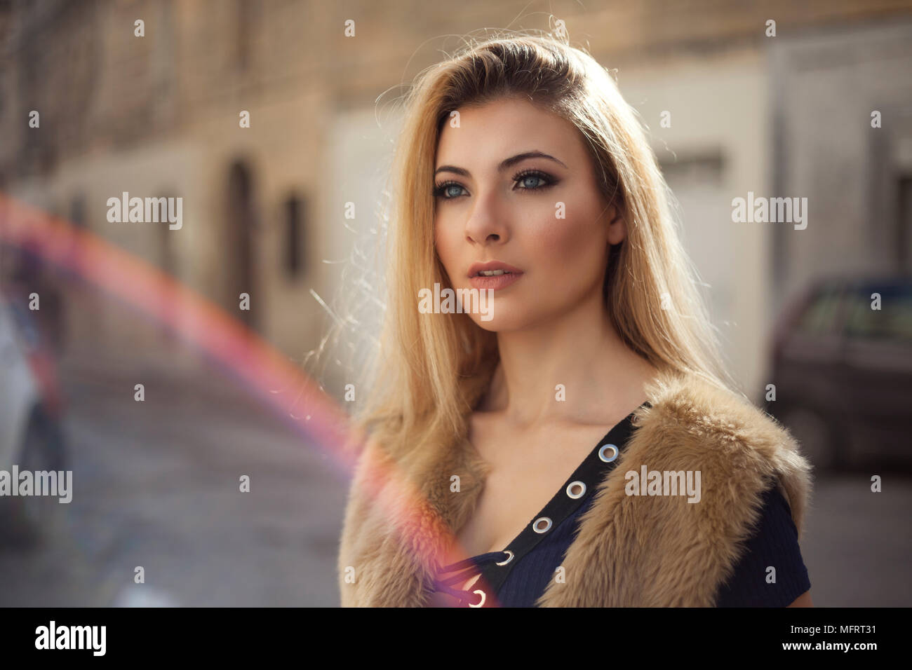 Blue eye model with blond hair with street in the background Stock Photo