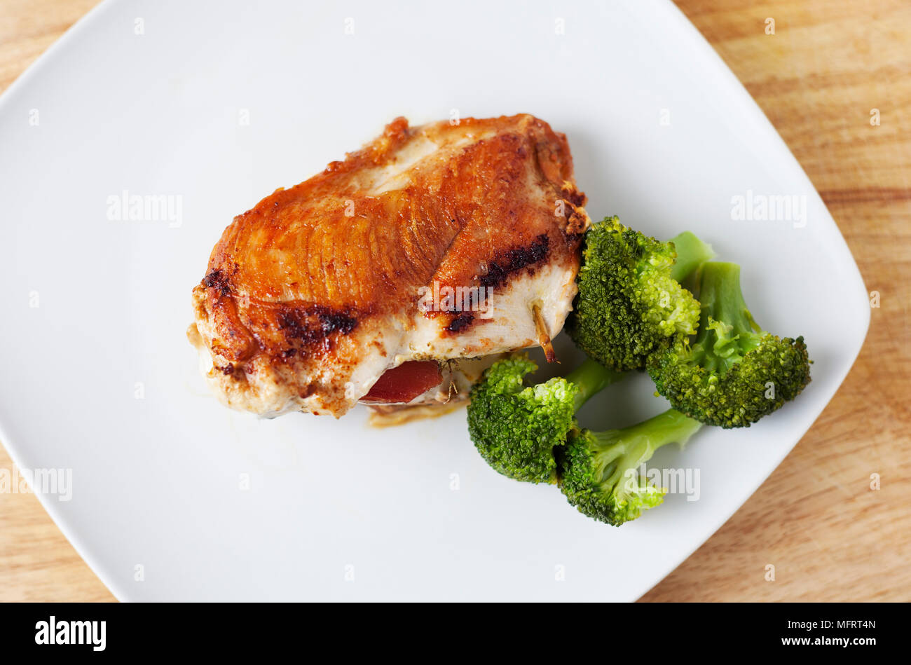 Fried chicken breast stuffed with mozzarella and Serbian ham, adding species such as oregano, smoked paprika, turmeric and pepper. Stock Photo