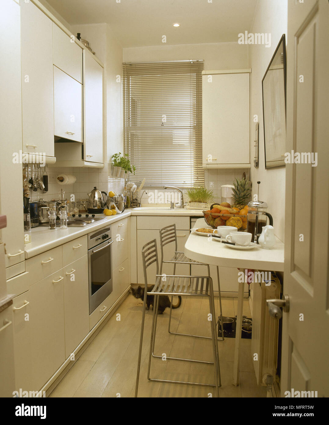 Galley kitchen breakfast bar set for breakfast. Stock Photo