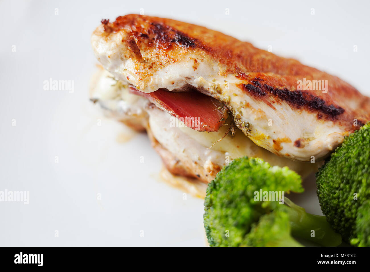 Fried chicken breast stuffed with mozzarella and Serbian ham, adding species such as oregano, smoked paprika, turmeric and pepper. Stock Photo