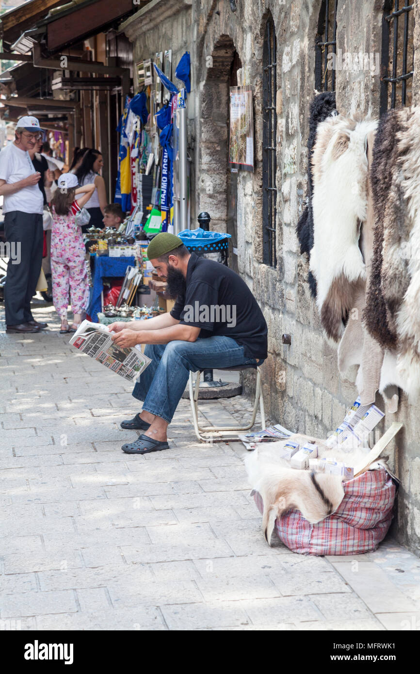 A Muslim man reading in front of Gazi Husrev-beg's Mosque, Sarajevo, Bosnia and Herzegovina Stock Photo