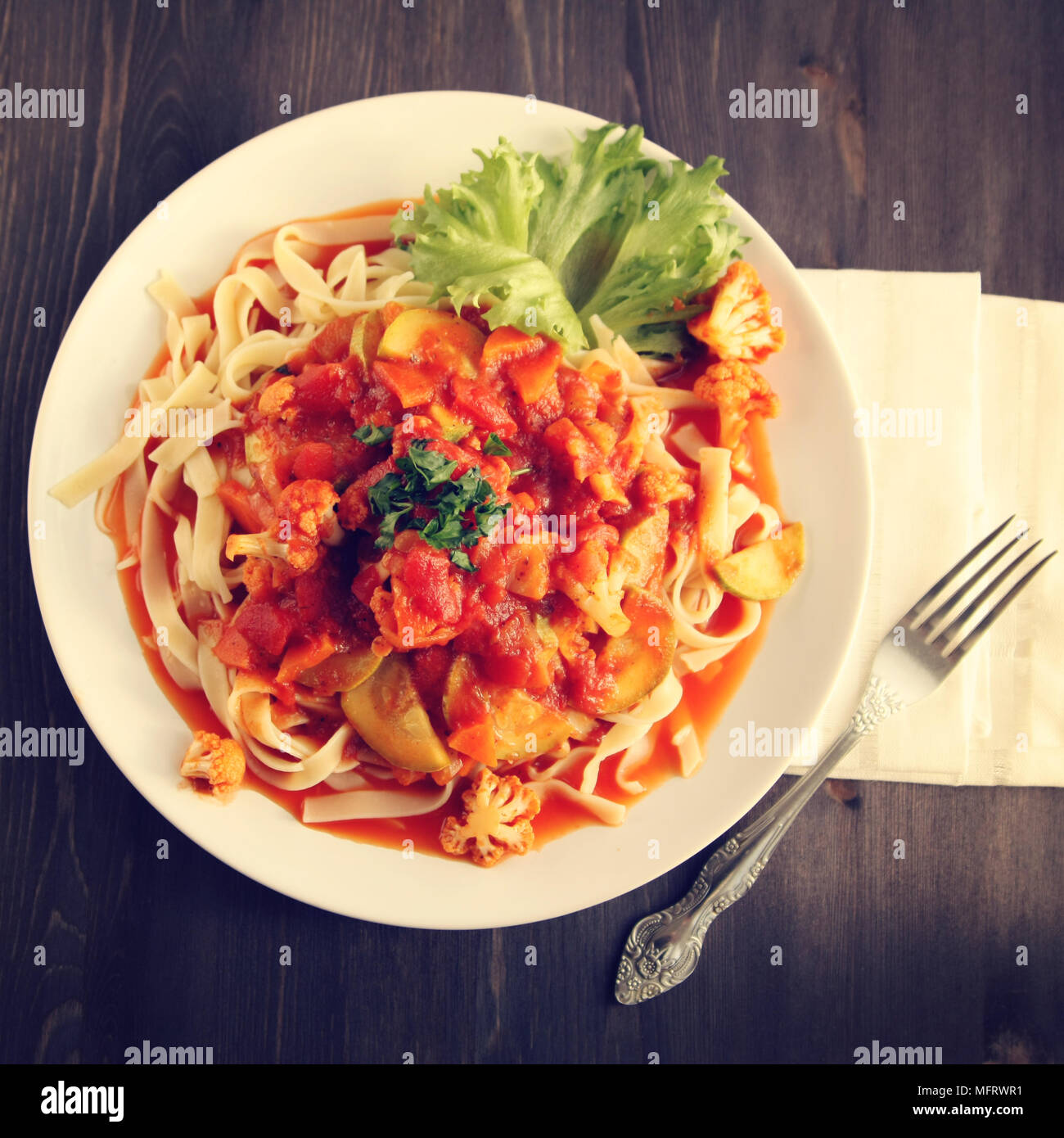 Ribbon pasta with Arrabiata sauce. Close up. Mediterranean dish. Tagliolini pasta with vegetables. Cauliflower, courgette and tomato stew. Italian cui Stock Photo