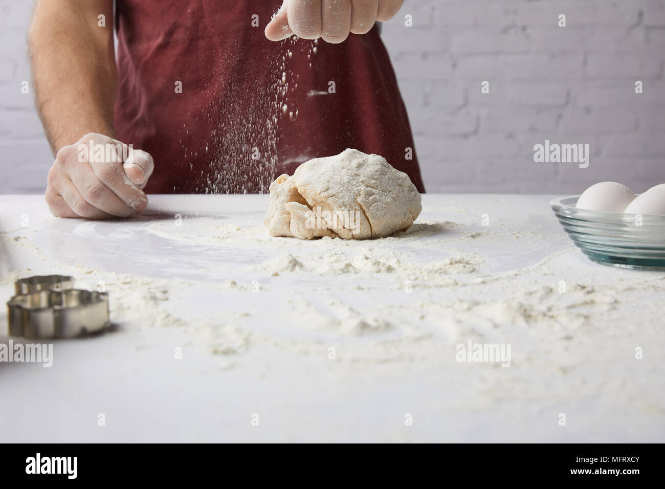 cropped image of chef preparing dough and adding flour Stock Photo
