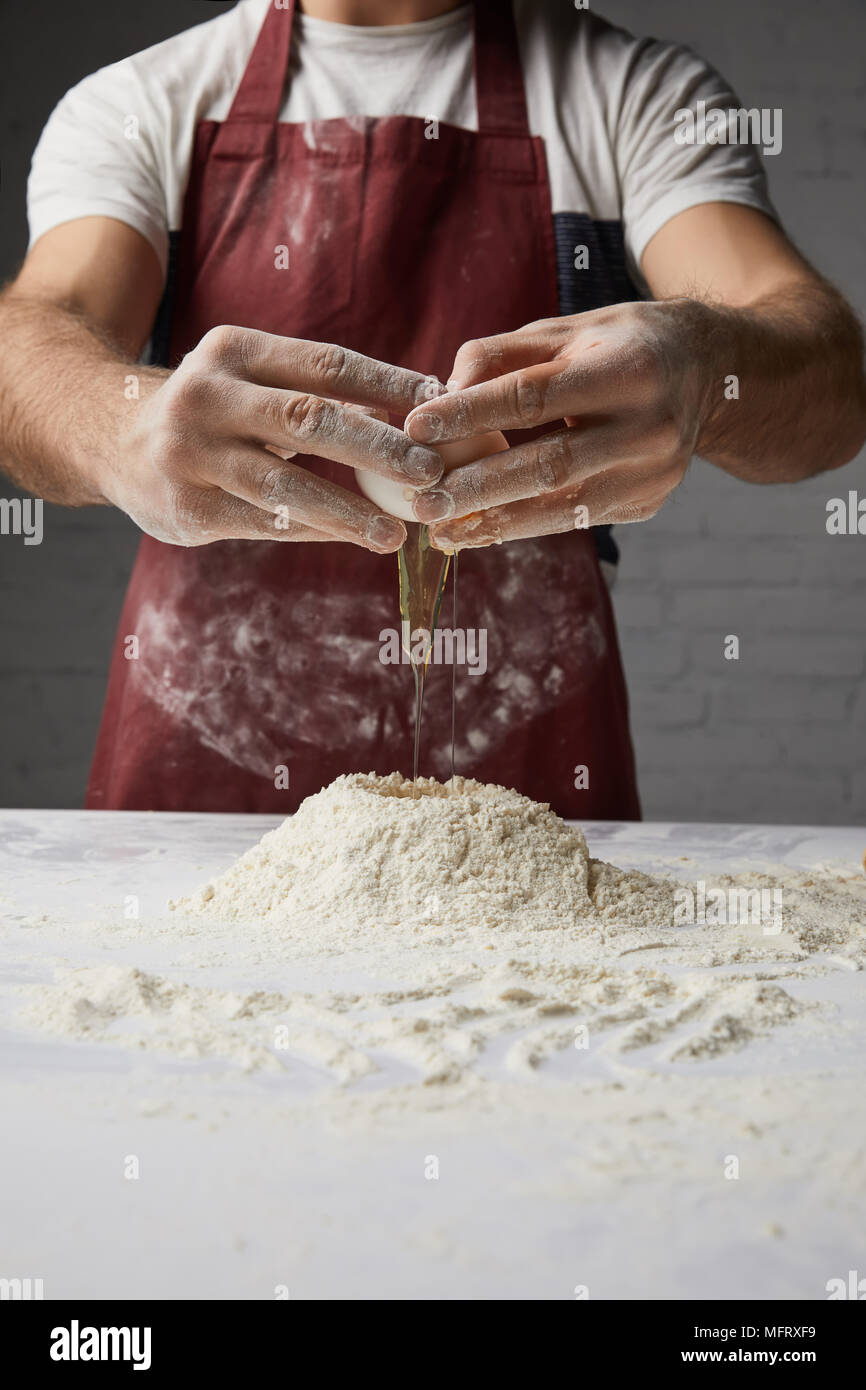 cropped image of chef preparing dough and adding egg Stock Photo