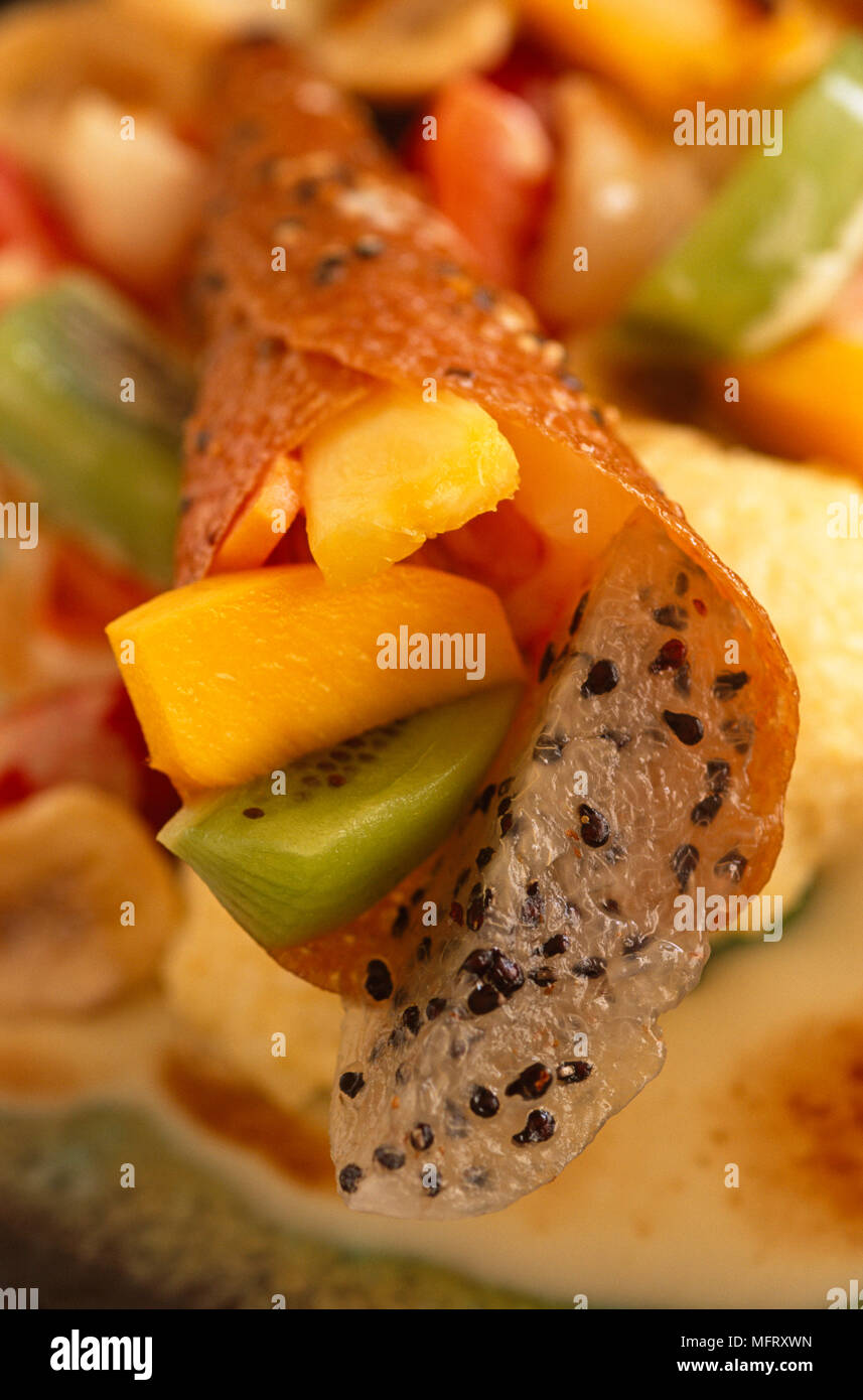 Fruit dessert of kiwi and mango fruit salad in pastry roll Stock Photo ...
