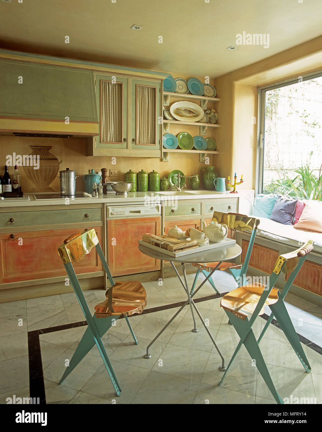 Round metal table and chairs with unusual copper seats in kitchen with