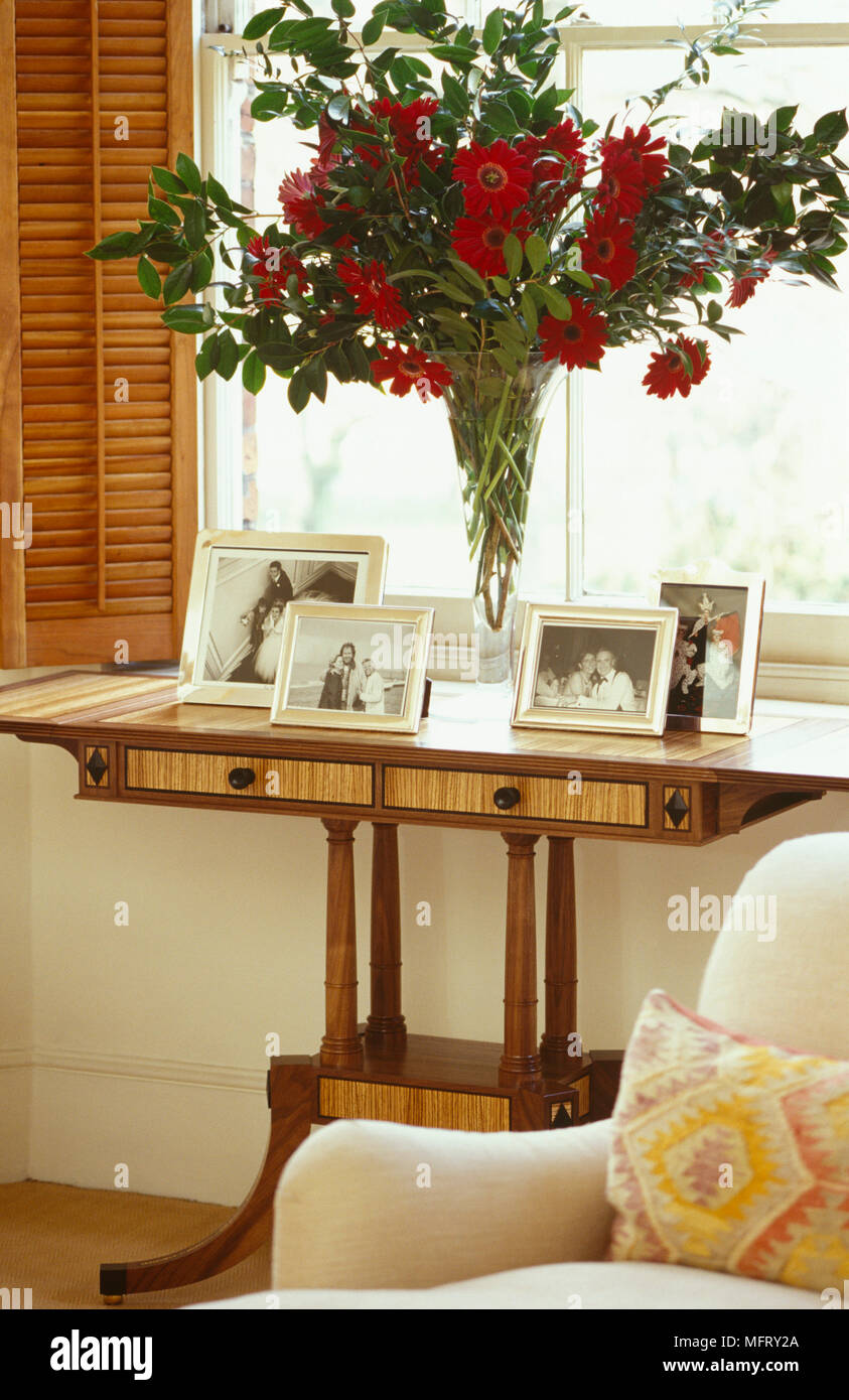 Arrangement Of Red Flowers On Wooden Console Table With Drawers