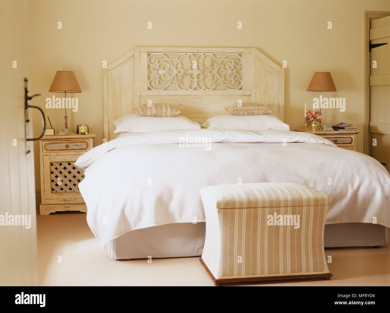 A traditional neutral bedroom with double bed carved headboard side
