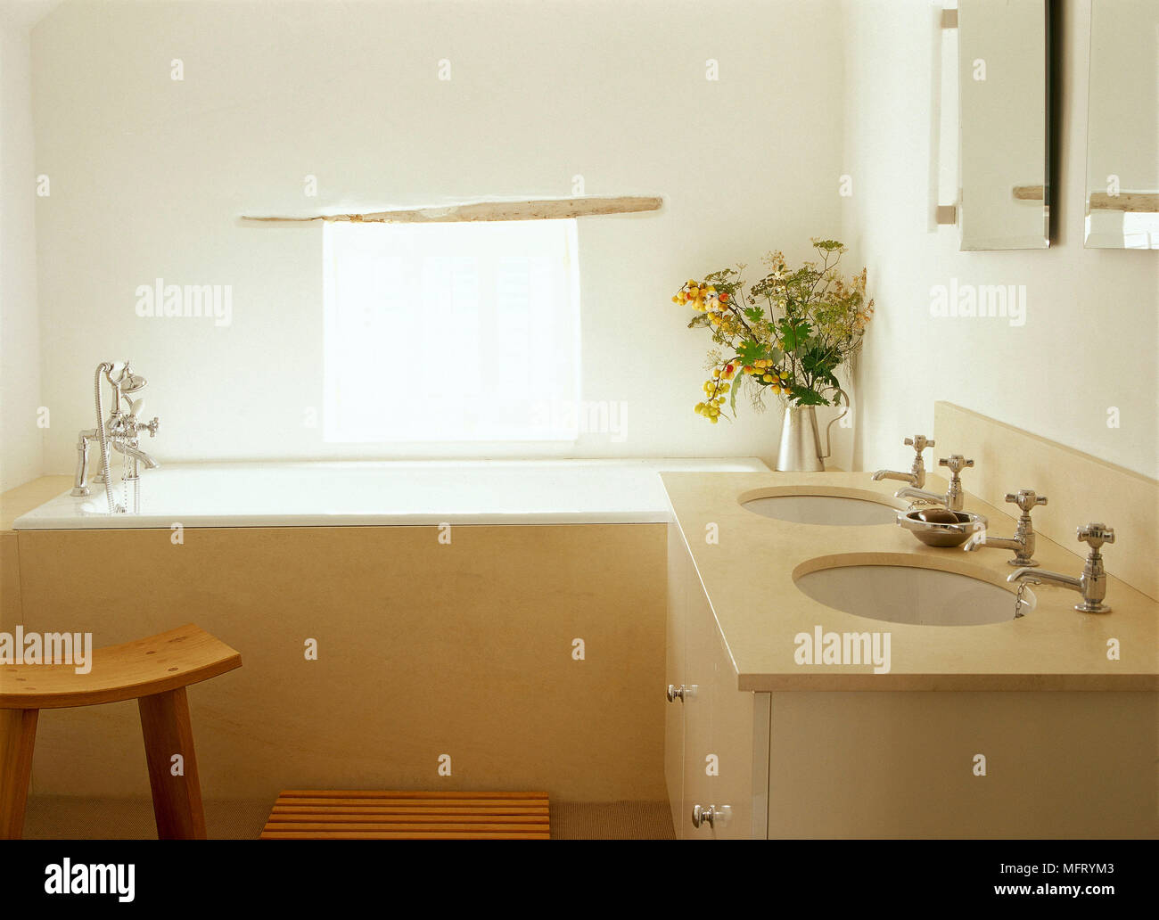 Modern neutral bathroom twin washbasins set in cupboard unit baths