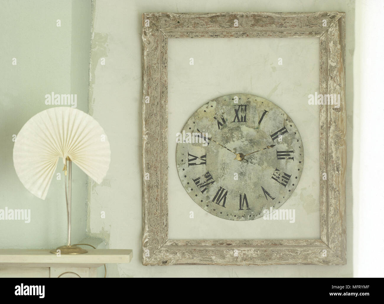 Painted clock in gold frame next to lamp on mantelpiece Stock Photo Alamy