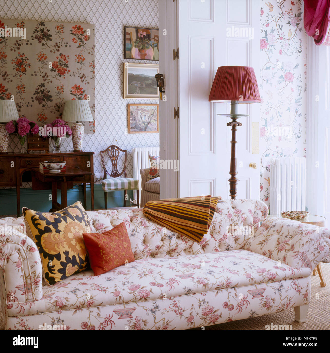 Sitting room with pink floral wallpaper upholstered sofa lamps Stock Photo