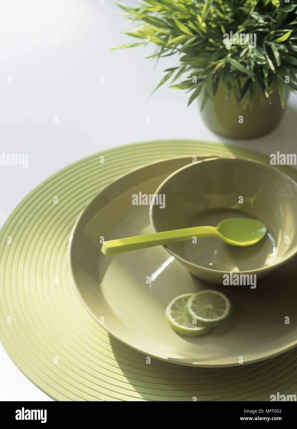 Green crockery stacked in geometric display with plant Stock Photo Alamy