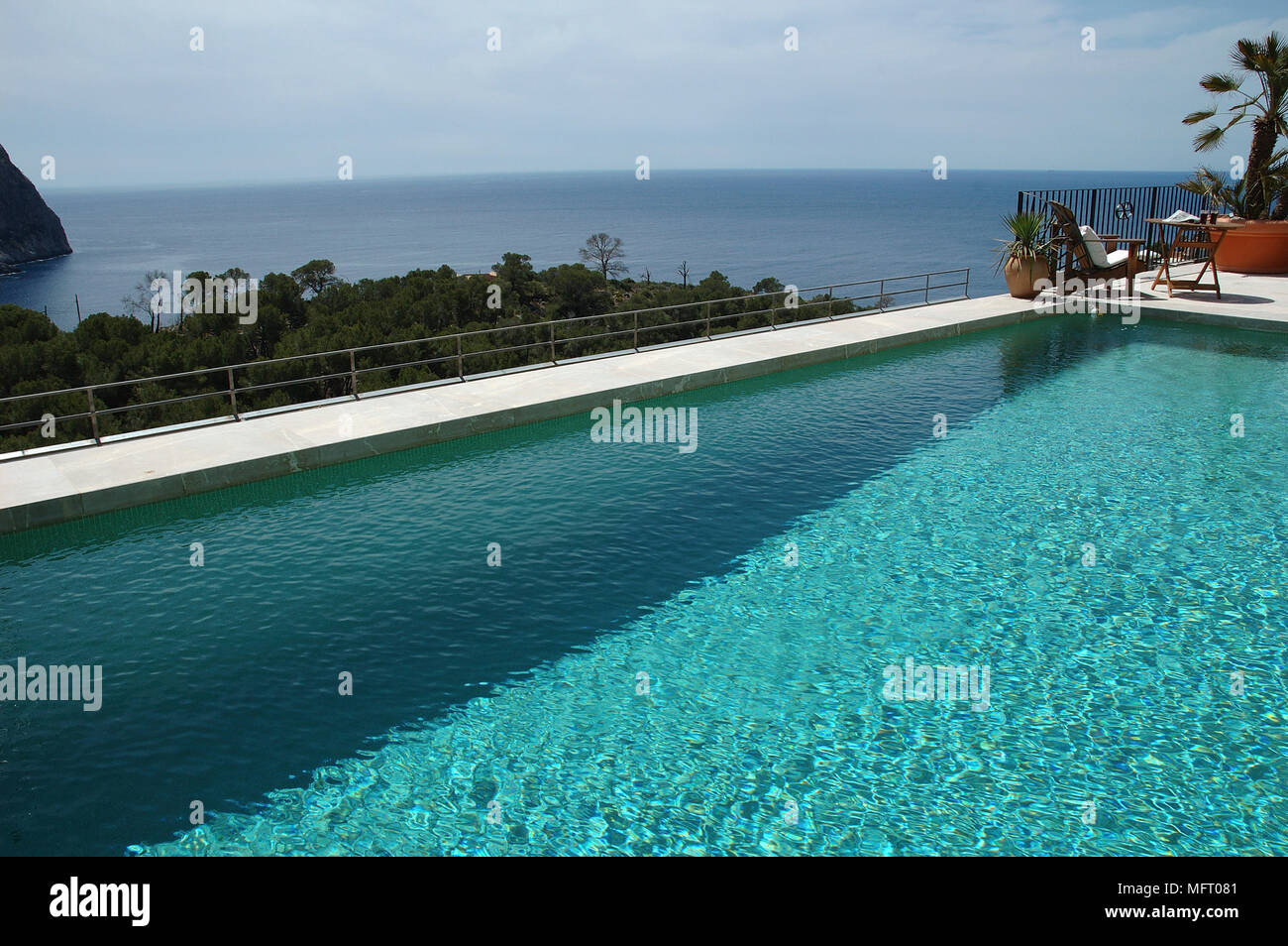 Chairs beside swimming pool overlooking ocean Stock Photo Alamy