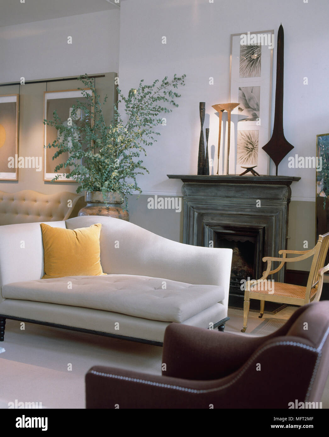 chase lounges indoors on Sitting Room With White And Green Walls Framed Artwork Fireplace With Sculpture Cream Chaise Lounge And A Leather Armchair Stock Photo Alamy