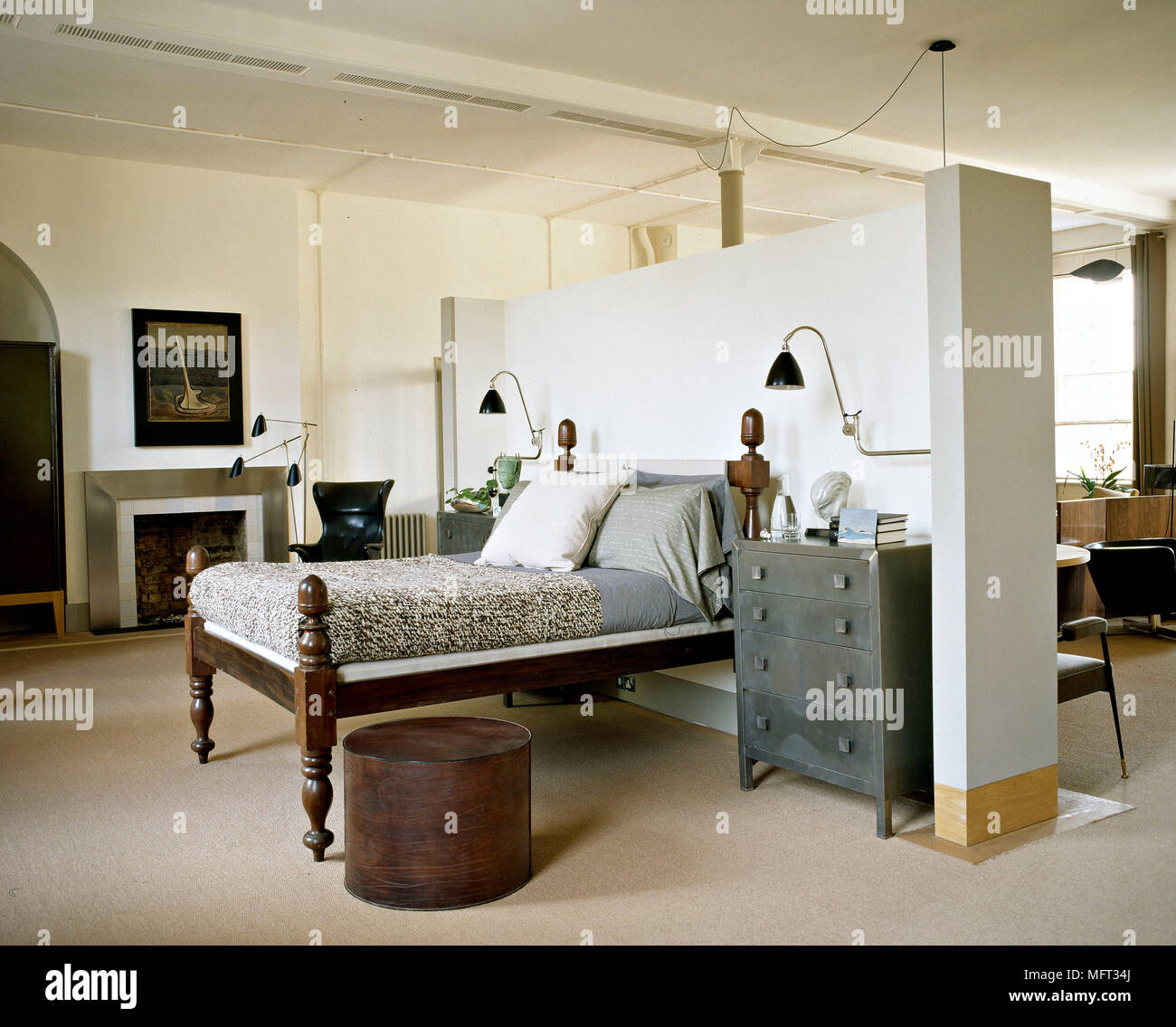 Open plan apartment with wooden bed behind partition wall Stock Photo