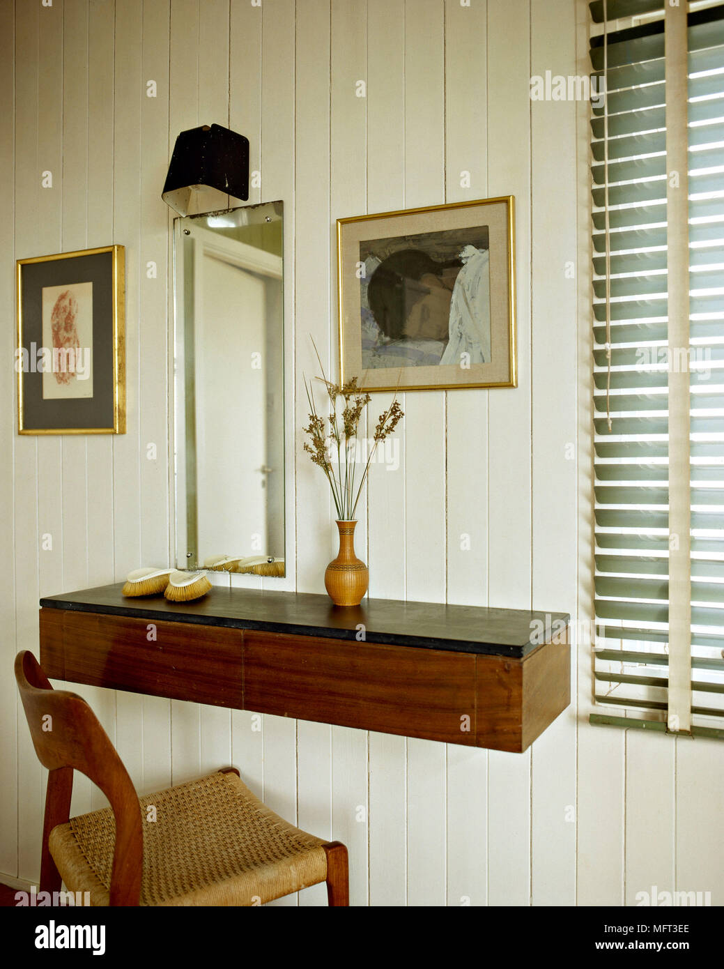 Mirror above wooden wall mounted dressing table with wooden chair Stock  Photo - Alamy