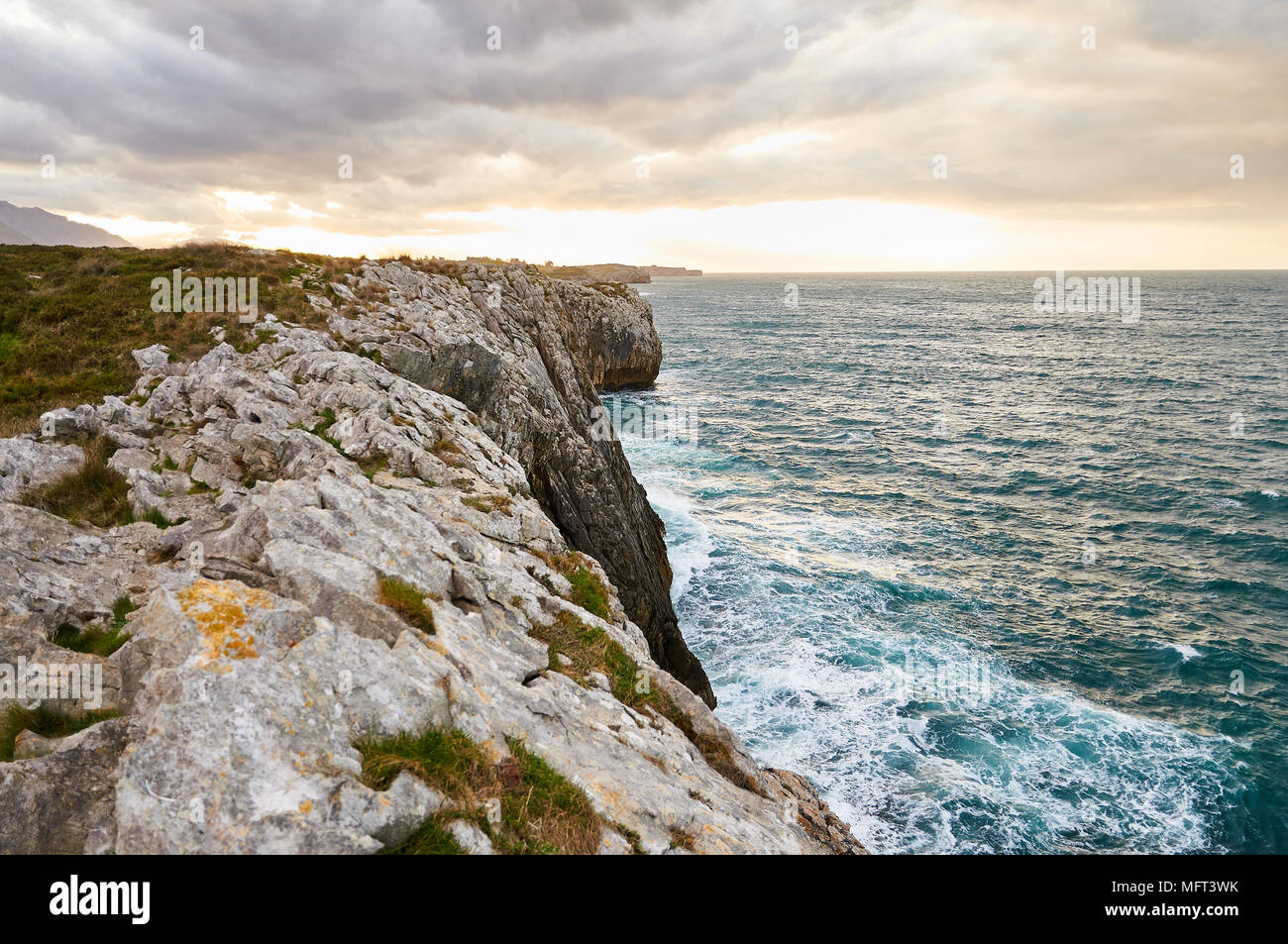 Scenery view of the Cantabrian sea coastline and cliffs in a cloudy sunset near Gulpiyuri beach (Naves, Llanes, Oriente, Asturias, Spain) Stock Photo