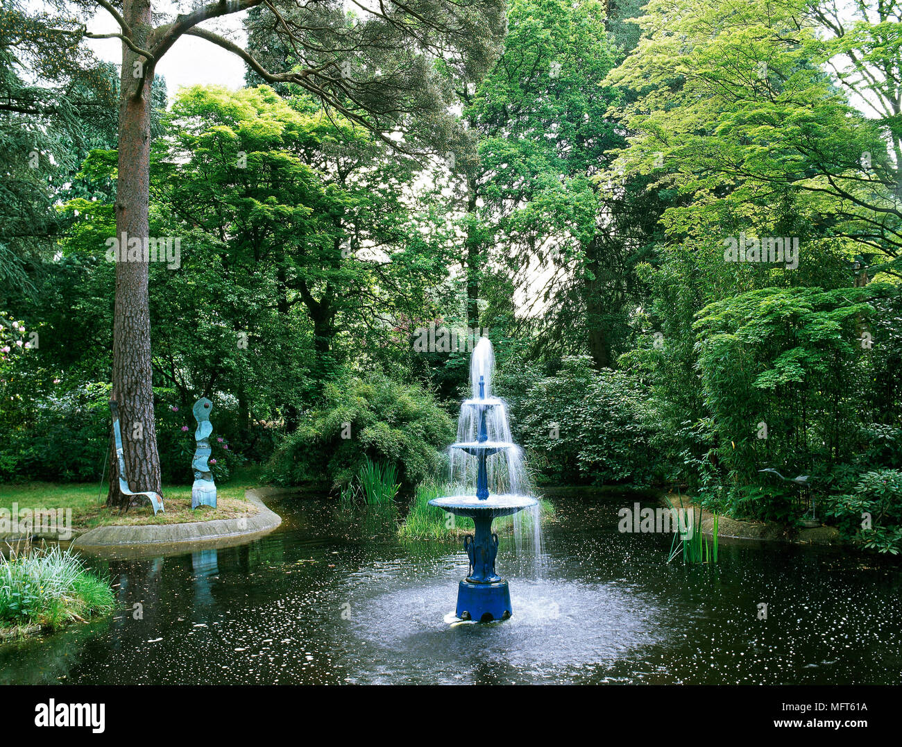 Woodland garden with pond and fountain water feature Stock Photo