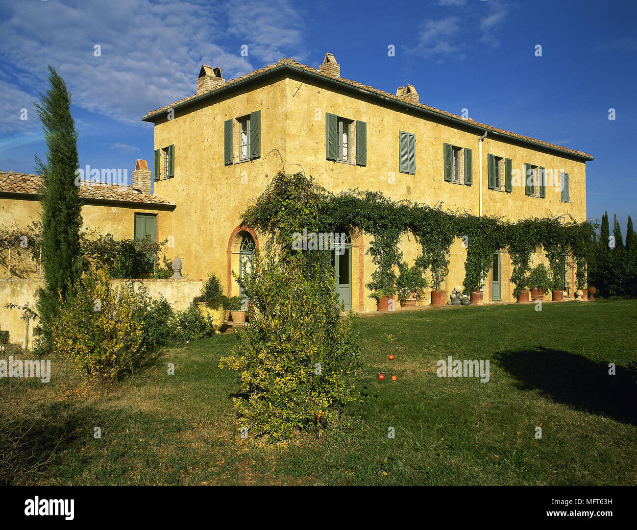 Exterior of a yellow painted Italian villa, window with shutters, Stock Photo
