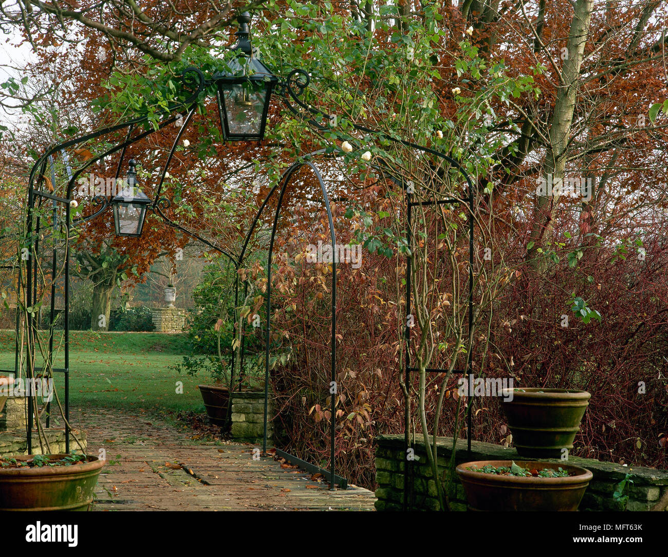 Autumn garden with pathway and wrought iron archway, Stock Photo