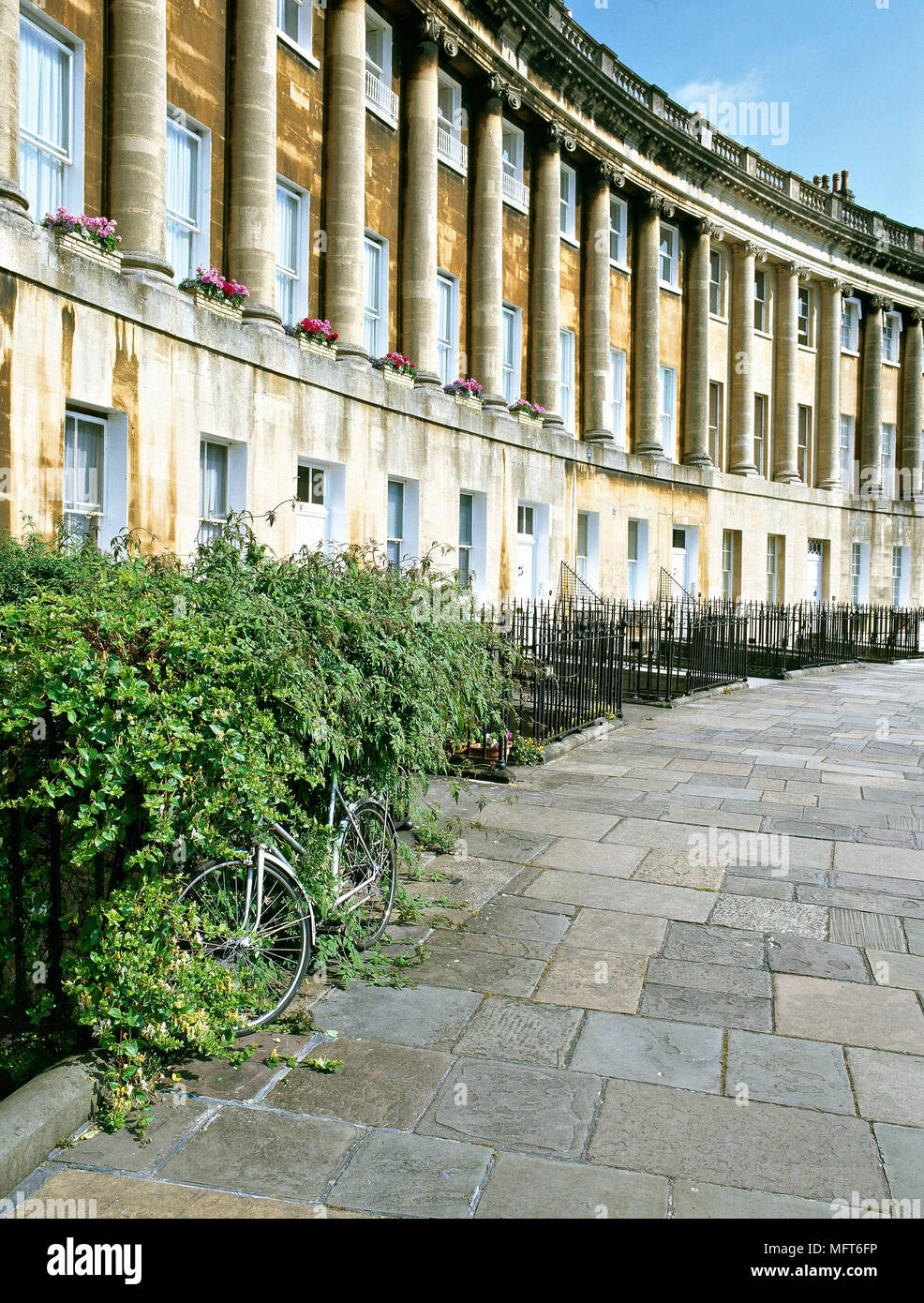 Exterior view of a column-lined apartment building bordering a Georgian crescent terrace. Stock Photo