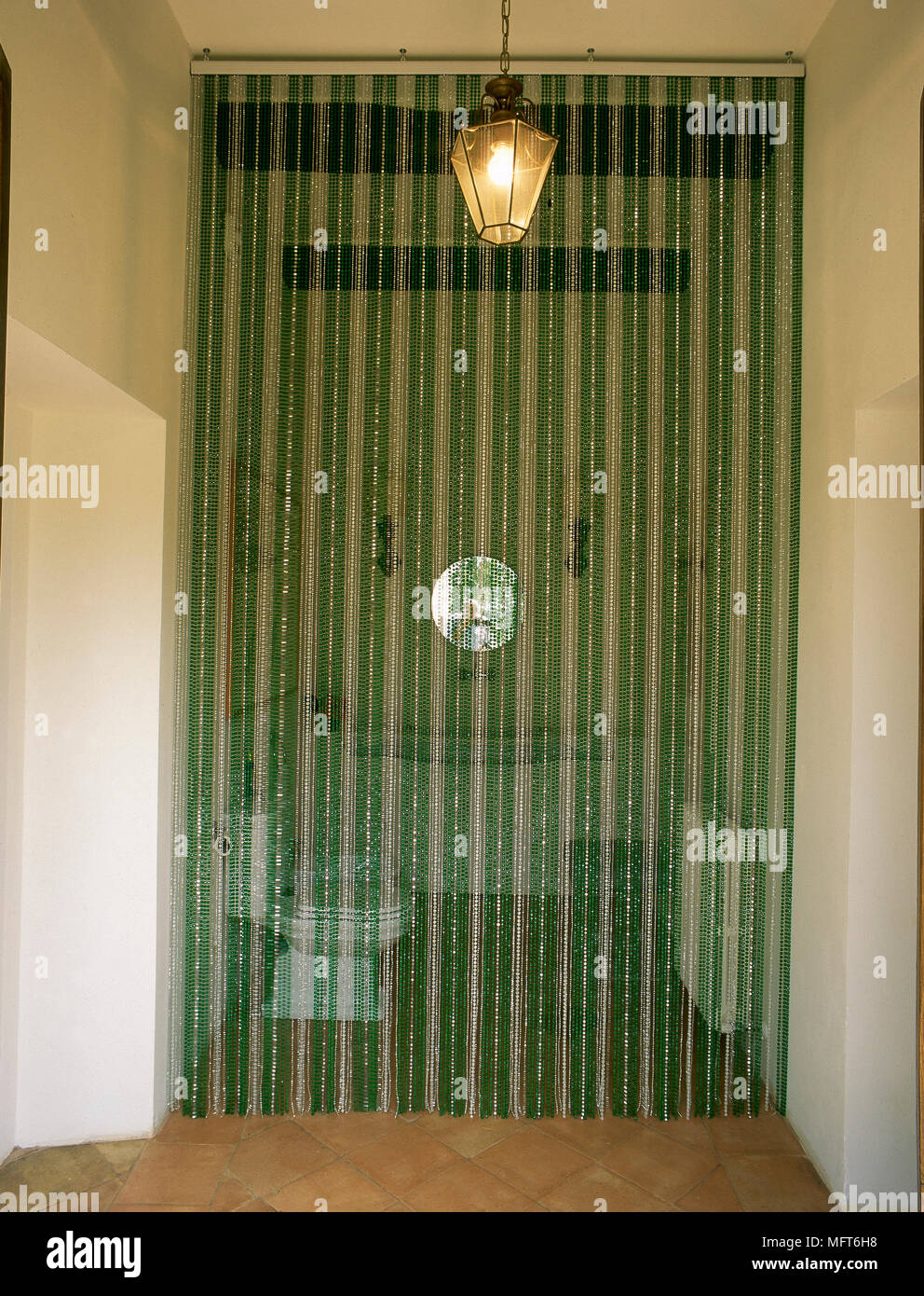 Beaded Curtain Over The Doorway To A Small Bathroom With Wooden